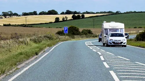 A car towing a caravan on a country A road