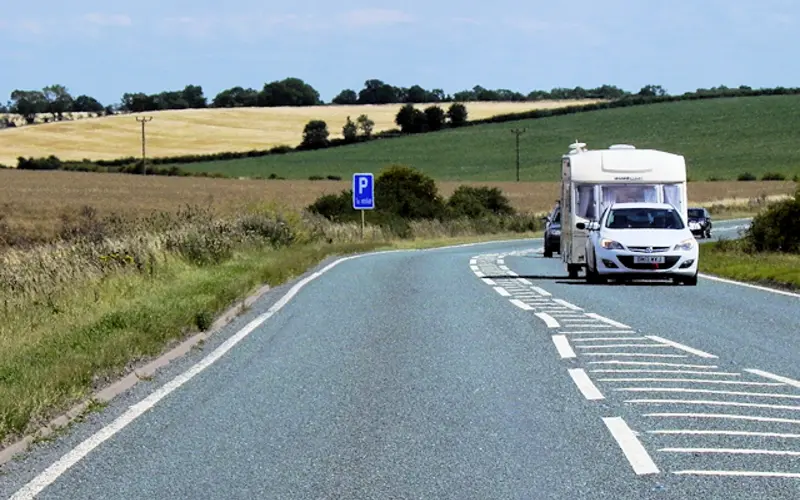 A car towing a caravan on a country A road