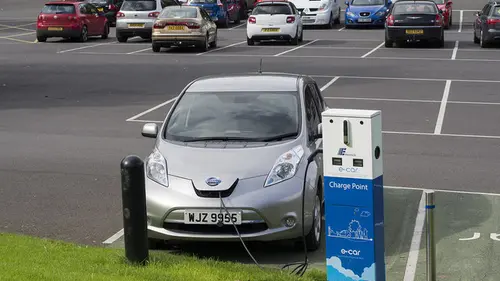 An electric car plugged in at a public charge point