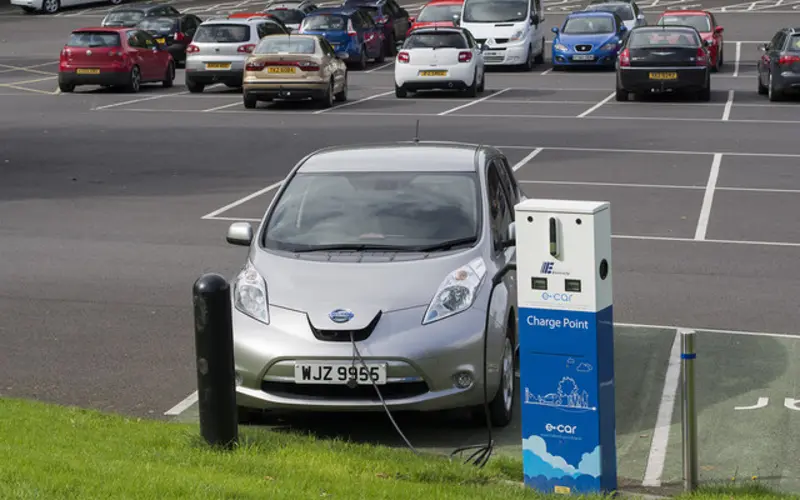 An electric car plugged in at a public charge point