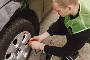 Tyre mechanic pumping air into a tyre