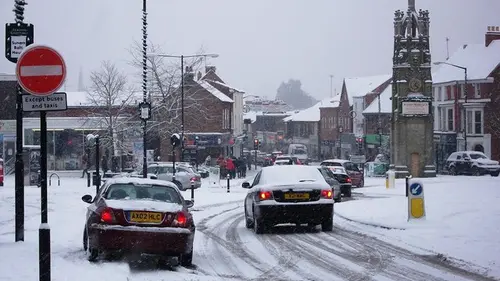 Cars driving on a snow-covered street in Kenilworth