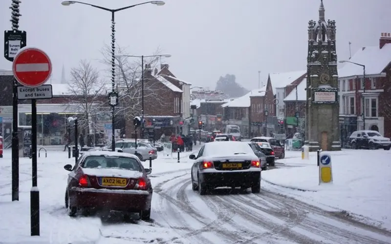 Cars driving on a snow-covered street in Kenilworth