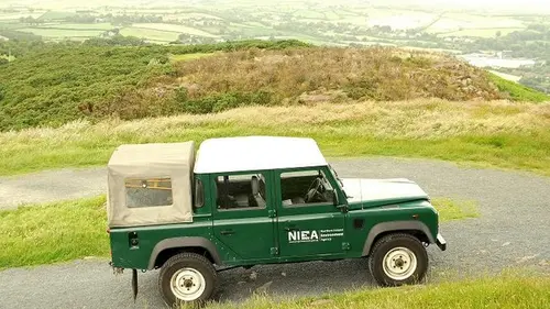A Land Rover parked on a hilltop track