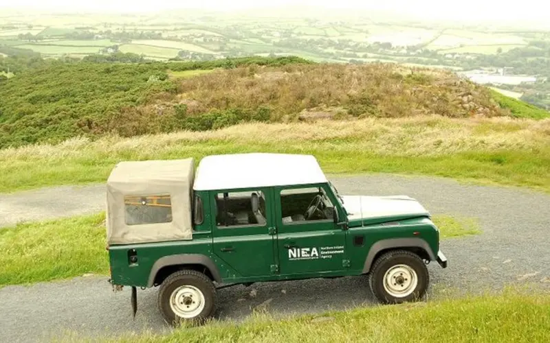 A Land Rover parked on a hilltop track