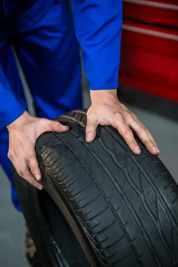 Mechanic showing a worn tyre