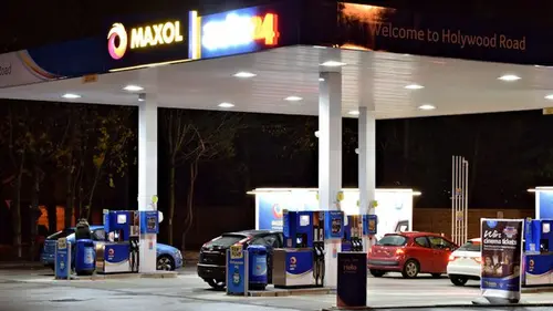 A petrol station forecourt at night, where many drivers check tyre pressures