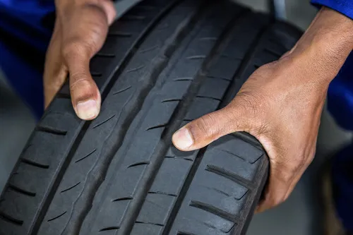 Tyre fitter holding tyre