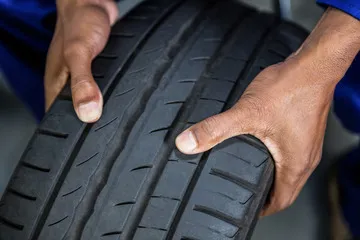 Mechanic checking tyre for signs of wear