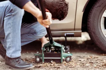 Man jacking up a car using a car jack