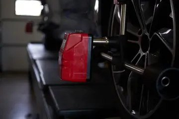 Mechanic using a wheel alignment machine